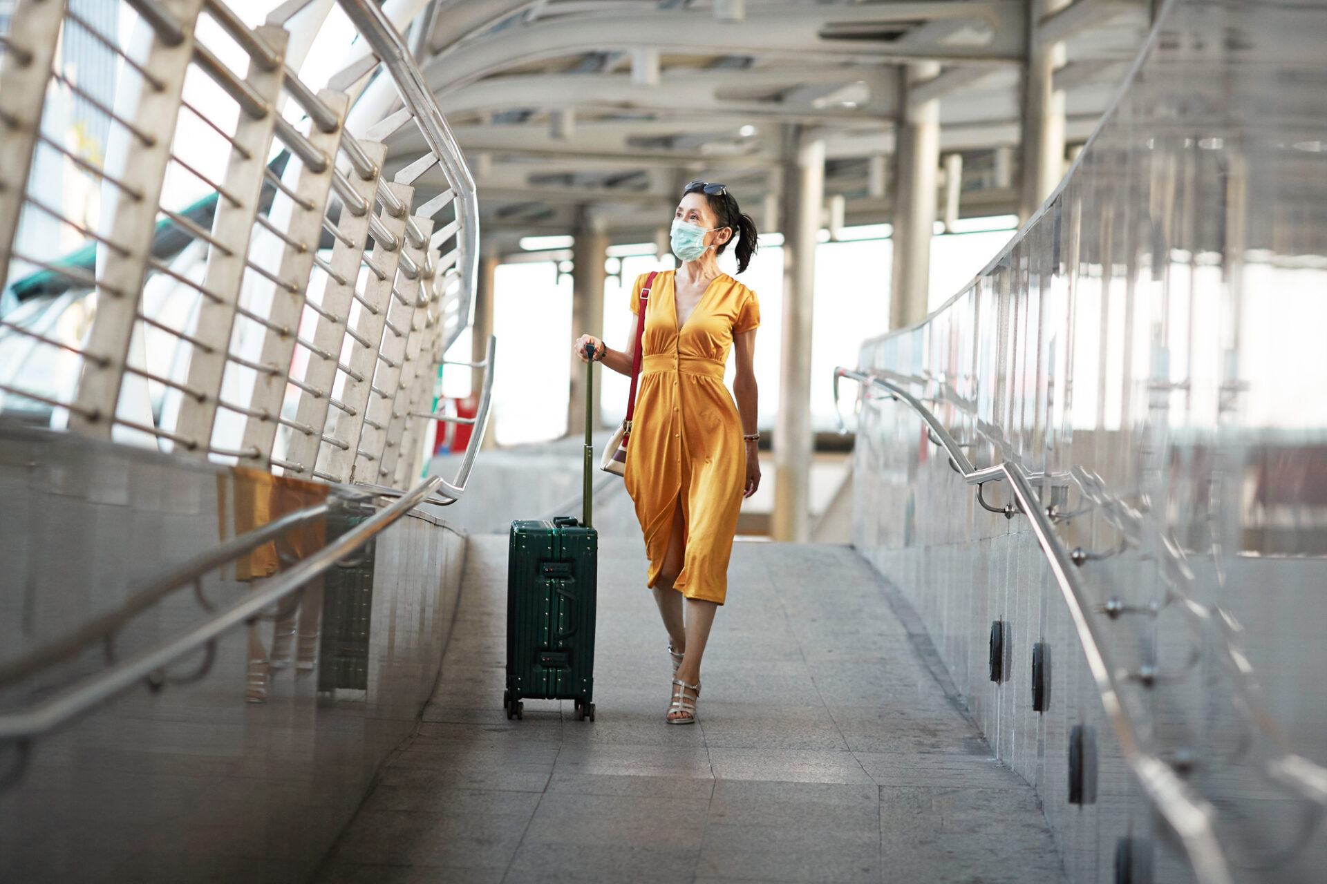 Woman walking with luggage at railroad station